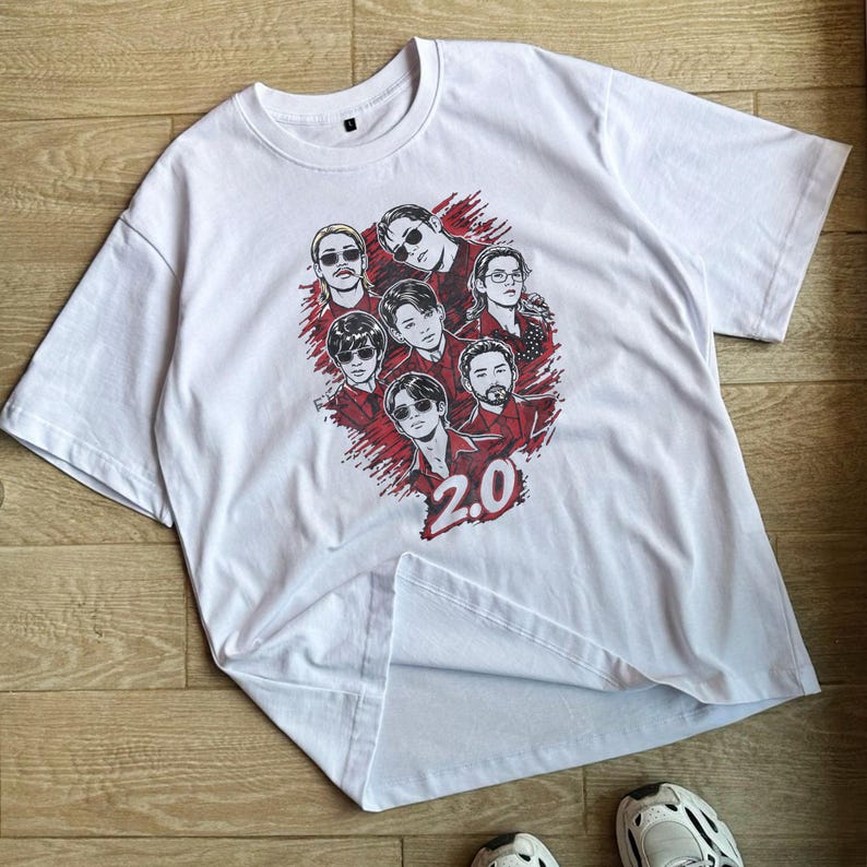 May include: White t-shirt featuring a graphic of seven people with sunglasses and the number 2.0 in red. The design is surrounded by red brushstrokes. The shirt is made of a soft, comfortable material.
