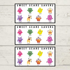 May include: Three black-framed prints featuring colorful cartoon monsters. Each print has the text "SWEET SCARE SAVERS" at the top. The monsters are in various colors, including pink, green, yellow, orange, and purple, with different eye configurations.