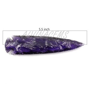 Könnte beinhalten: Ein violetter Pfeilspitze, etwa 14 cm lang, mit strukturierter Oberfläche. Die Pfeilspitze hat eine tiefviolette Farbe und eine scharfe Spitze. Der Text "ALVINAGEMS" ist im Hintergrund sichtbar.