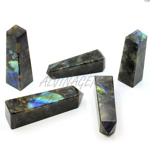 May include: Five labradorite obelisks with a dark gray base color and iridescent blue, green, and yellow flashes. The obelisks are rectangular with a pointed top. The word "ALVINAGENS" is visible in the image.