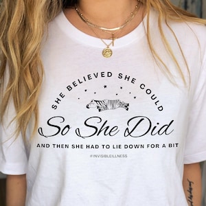 May include: White t-shirt with a black graphic of a zebra lying down and the text "SHE BELIEVED SHE COULD So She Did AND THEN SHE HAD TO LIE DOWN FOR A BIT #INVISIBLEILLNESS"