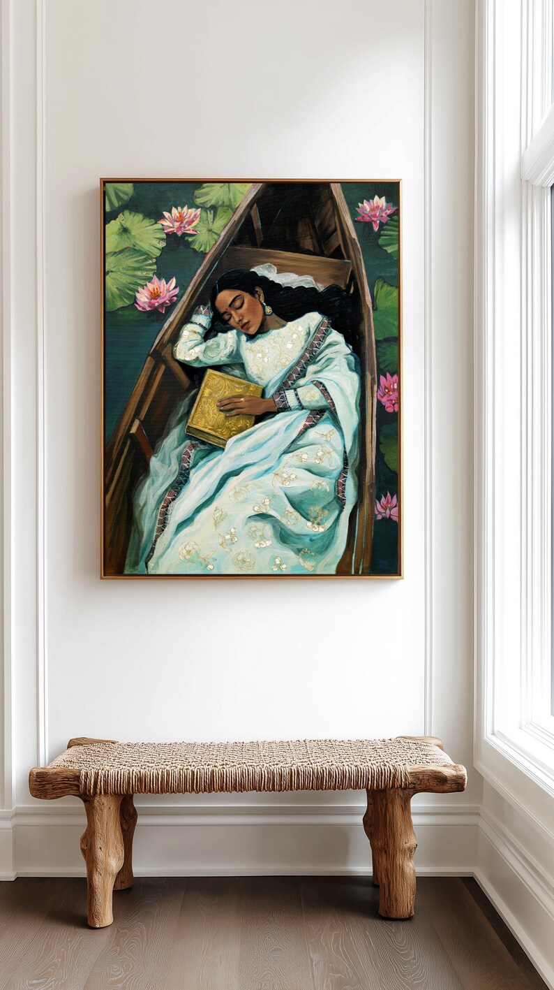 Puede incluir: Pintura al &oacute;leo de una persona dormida en un bote de madera, rodeada de nen&uacute;fares y flores de loto rosas. La persona lleva un vestido azul claro y sostiene un libro dorado. La obra est&aacute; enmarcada.