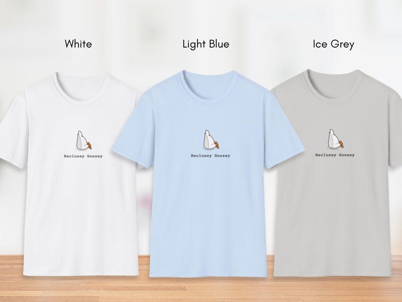 May include: Three t-shirts in white, light blue, and ice grey with a cartoon goose design and the text "Reclusive Goosey".