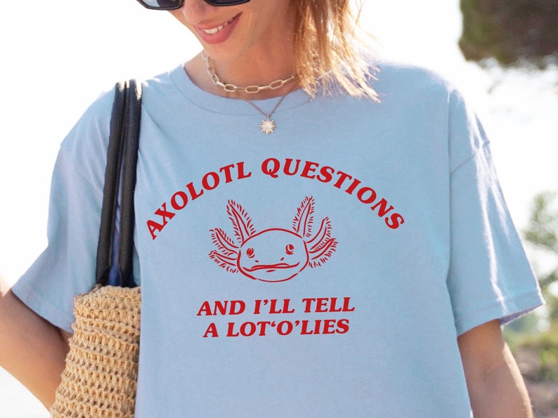 May include: Light blue t-shirt with a red axolotl graphic and the text "Axolotl Questions and I'll Tell A Lot'o'Lies".