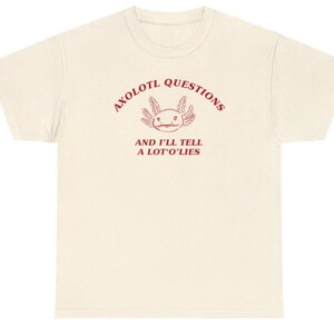 May include: Axolotl Questions and I'll Tell a Lot O' Lies. A white t-shirt with a red axolotl graphic and text.