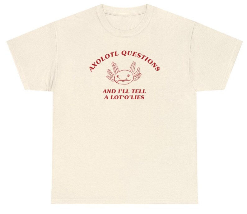 May include: Axolotl Questions and I'll Tell a Lot O' Lies. A white t-shirt with a red axolotl graphic and text.
