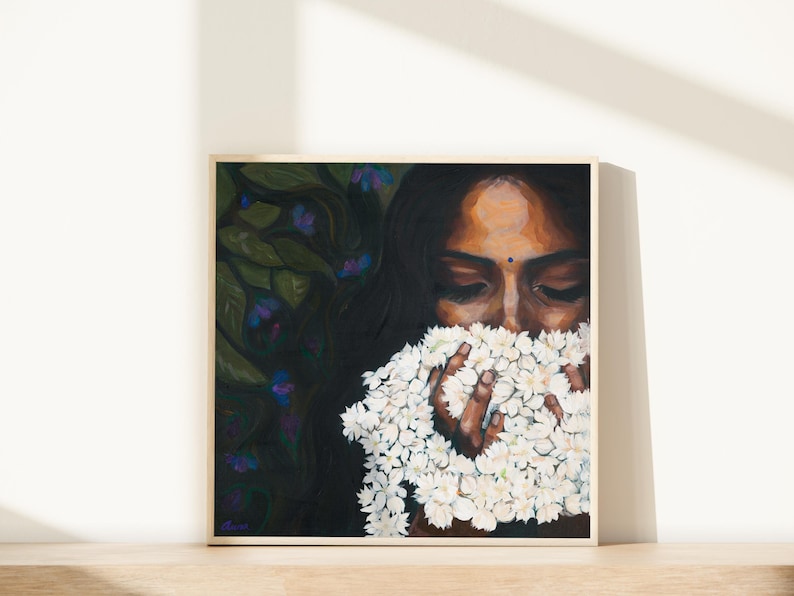 Puede incluir: Una pintura cuadrada en un marco de madera clara que representa a una persona de cabello oscuro con un peque&ntilde;o bindi azul, sosteniendo un gran racimo de flores de jazm&iacute;n blancas cerca del rostro. El fondo muestra follaje verde oscuro con flores moradas.