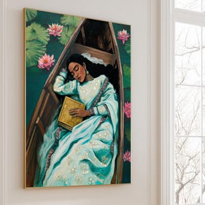 Puede incluir: Pintura al &oacute;leo de una persona con un sari azul claro, dormida en un bote de madera. La persona sostiene un libro dorado, rodeada de flores de loto rosas y hojas de nen&uacute;far verdes. La obra est&aacute; enmarcada en un marco dorado.