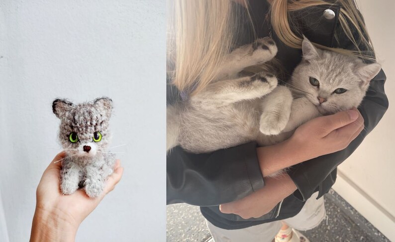 May include: A gray and white crocheted cat toy with green eyes. The toy is being held in a person's hand.