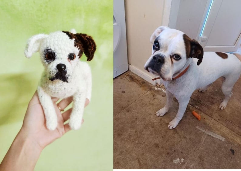 Op de afbeelding: Een gehaakt wit en bruin honden speelgoed met zwarte ogen en een zwarte neus. Het speelgoed wordt in de hand van een persoon gehouden.