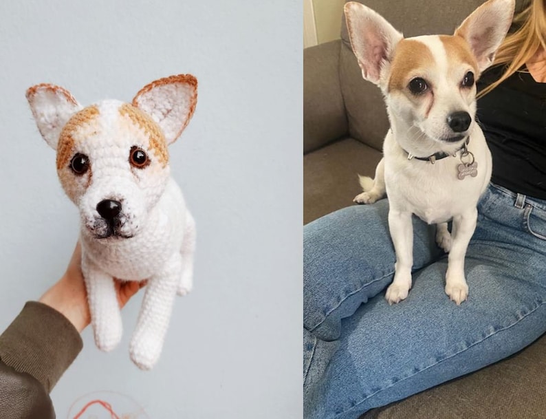 May include: A crocheted stuffed dog toy with brown and white fur, sitting in a person's hand. The dog has a white collar with a silver tag.