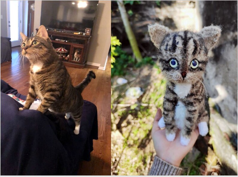 May include: A brown tabby cat with white markings is standing on a couch. Next to it is a felted replica of the cat, with blue eyes and white paws.