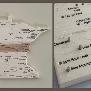 Peut inclure: Une carte en bois du Minnesota avec les noms des lacs et des villes indiqués. La carte est divisée en sections, chacune d'une couleur différente. La carte est montée sur un cadre en bois.