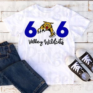 Könnte beinhalten: Weißes T-Shirt mit der blauen Zahl 6, einer gelb-schwarzen Wildkatzen-Grafik und dem Schriftzug "Valley Wildcats" in schwarzer Schrift. Das Shirt wird mit blauen Jeans und schwarz-weißen Turnschuhen gezeigt.