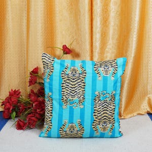 May include: A blue and white striped throw pillow with a repeating pattern of tigers. The tigers are facing upwards with their paws in the air.