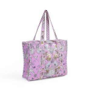 Puede incluir: Una bolsa de mano rosa con estampado tropical que incluye monos, pájaros y palmeras. La bolsa tiene un ribete a rayas blanco y rosa y dos asas largas.