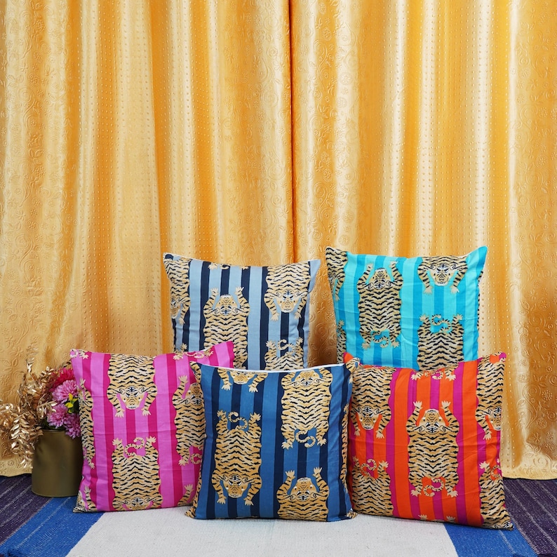 May include: Five decorative throw pillows with a tiger print on a striped background. The pillows are in various colors, including pink, blue, and turquoise.