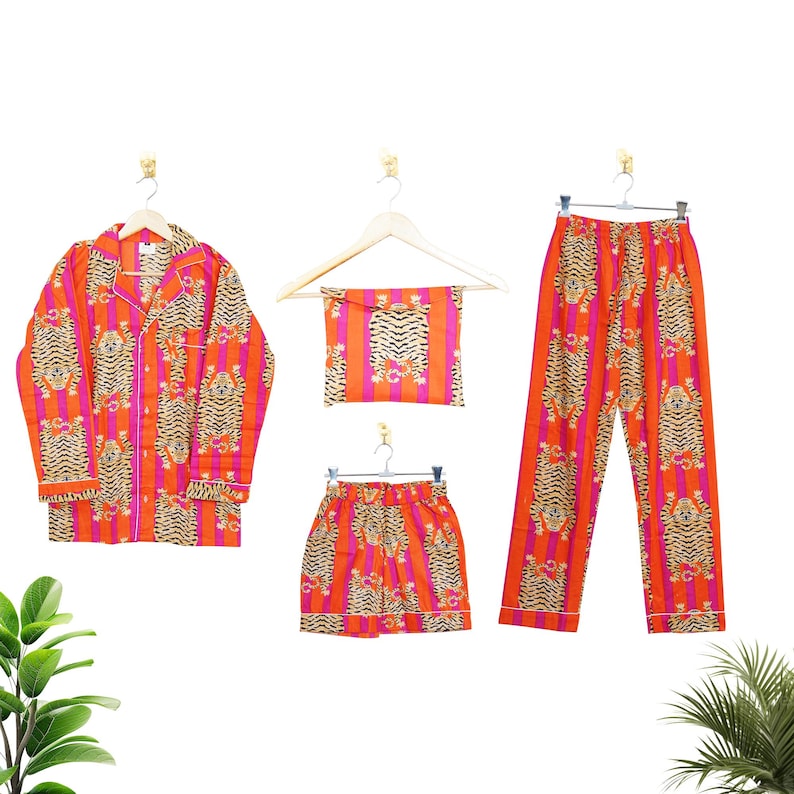 "Vibrant orange and pink vertical striped pajama set featuring a repeating tiger animal print. This 4-piece women's cotton nightwear collection includes a long-sleeve button-down shirt with collar and piping, full-length pajama pants, matching shorts, and a fabric envelope pouch. Indian block print style loungewear perfect for boho bridesmaid gifts, bachelorette parties, or summer sleepwear. Soft breathable fabric with funky safari design."