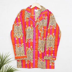 "Vibrant orange and pink vertical striped pajama set featuring a repeating tiger animal print. This 4-piece women's cotton nightwear collection includes a long-sleeve button-down shirt with collar and piping, full-length pajama pants, matching shorts, and a fabric envelope pouch. Indian block print style loungewear perfect for boho bridesmaid gifts, bachelorette parties, or summer sleepwear. Soft breathable fabric with funky safari design."