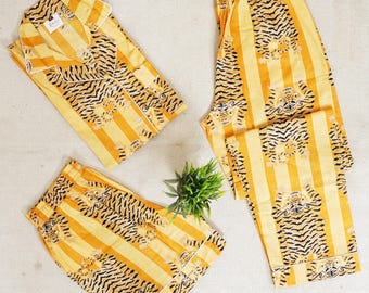 May include: A yellow and black striped pajama set with a tiger print. The set includes a long-sleeved shirt and pants.