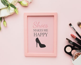 Könnte beinhalten: Ein rosa gerahmtes Bild mit dem Text "Shoes makes me happy" und einer schwarzen Silhouette eines High-Heel-Schuhs. Das Bild befindet sich auf einem rosa Hintergrund mit weißen Blumen und Make-up-Pinseln.