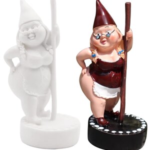 May include: Two garden gnome figurines. One is white, the other is painted with a burgundy top, white apron, and a dark red hat. Both gnomes are holding a wooden pole and standing on a round base.
