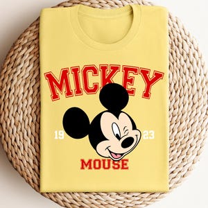 a yellow mickey mouse shirt sitting on top of a basket