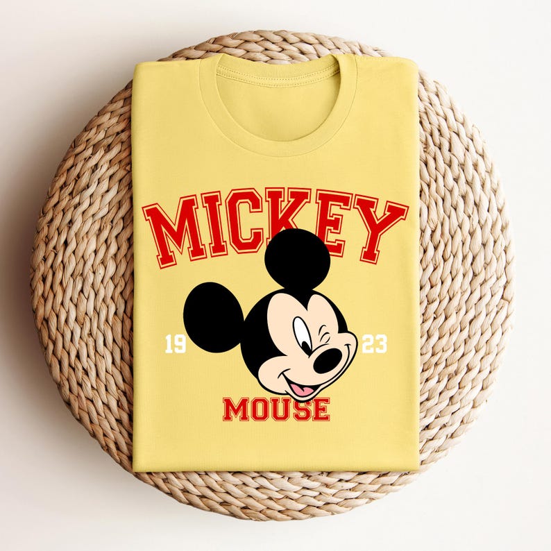 a yellow mickey mouse shirt sitting on top of a basket