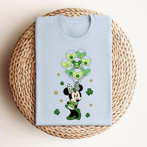 a blue shirt with a mickey mouse holding shamrocks