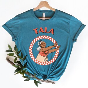 a t - shirt with a picture of a woman holding a tennis racquet