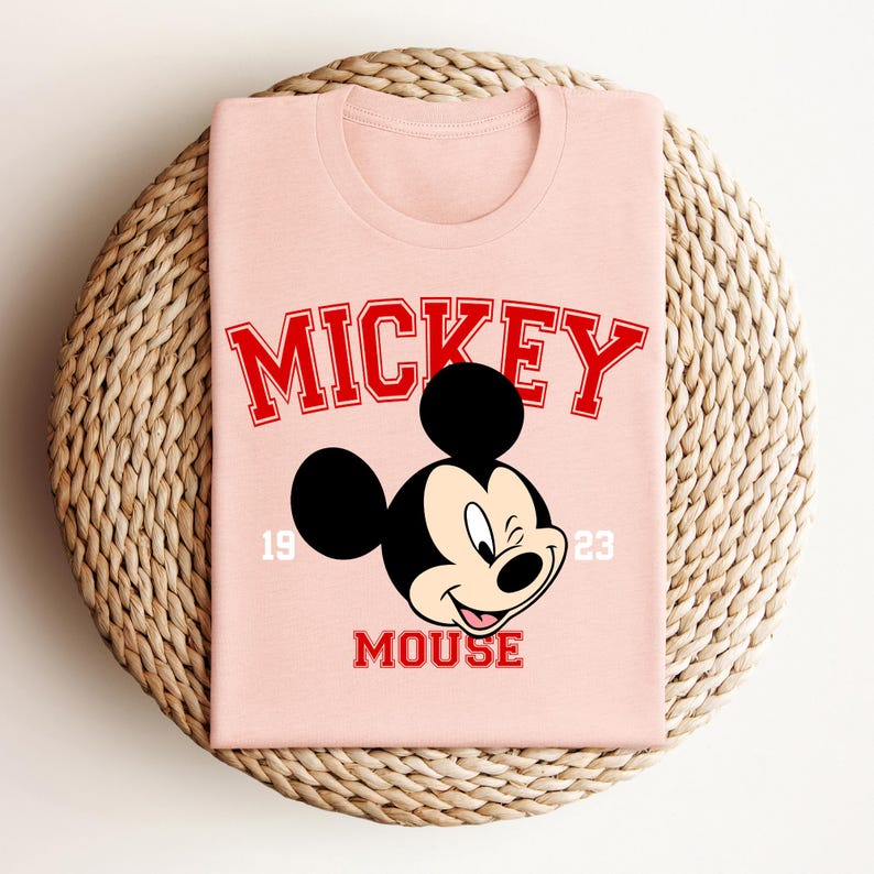 a pink mickey mouse shirt sitting on top of a wicker basket
