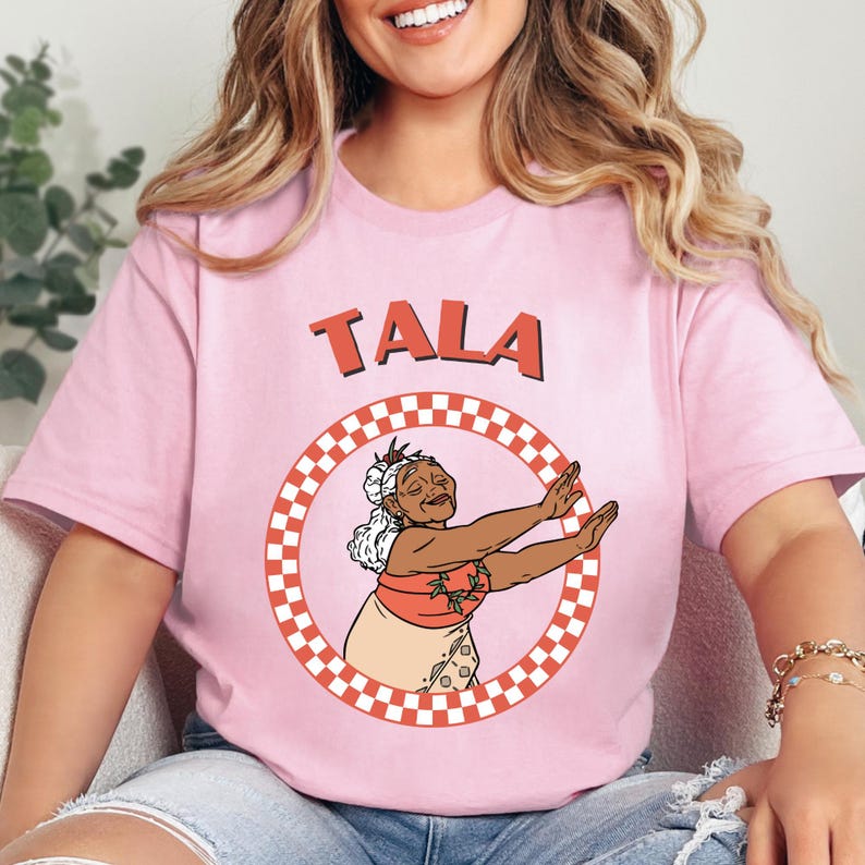 a woman sitting on a couch wearing a pink shirt