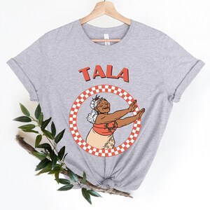 a t - shirt with a picture of a woman holding a tennis racket