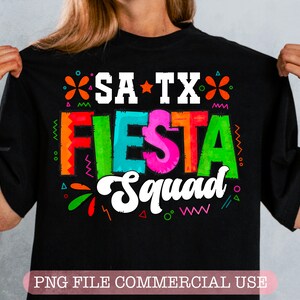 May include: Black t-shirt with a colorful graphic design that says "SA TX FIESTA Squad".