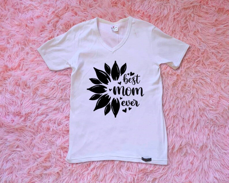Op de afbeelding: Wit T-shirt met een zwart zonnebloemontwerp en de tekst "best mom ever".