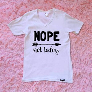 May include: White v-neck t-shirt with black text that reads "NOPE not today" and a black arrow graphic.