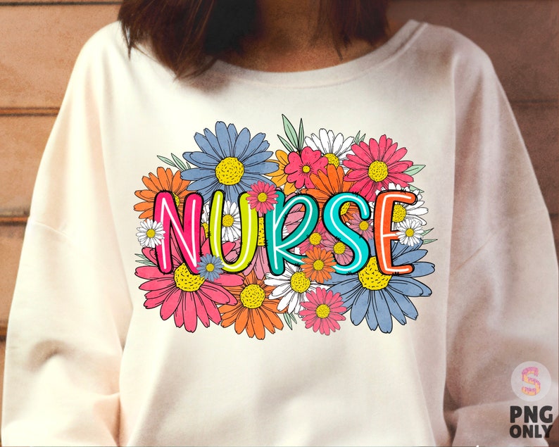 May include: A white sweatshirt with a colorful floral design and the word "NURSE" in the center. The flowers are in shades of pink, blue, yellow, and orange.