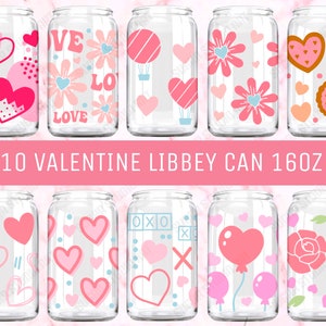 Op de afbeelding: Tien doorzichtige glazen Libby-blikken van 473 ml met roze en witte Valentijnsdagthema's. De ontwerpen omvatten harten, bloemen, XOXO en een luchtballon.