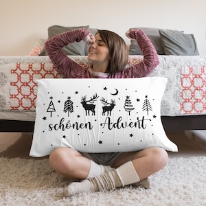May include: White pillow with black illustrations of Christmas trees, reindeer, and a crescent moon. The text "sch&ouml;nen Advent" is printed on the pillow.