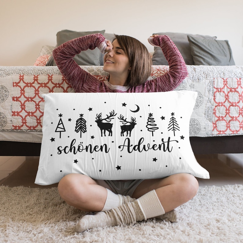 May include: White pillow with black illustrations of Christmas trees, reindeer, and a crescent moon. The text "sch&ouml;nen Advent" is printed on the pillow.