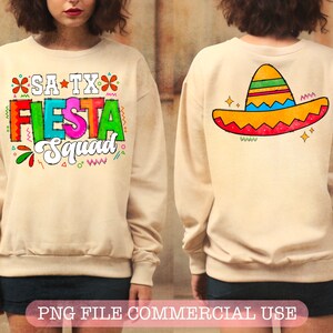 May include: A beige sweatshirt with the text "SA TX Fiesta Squad" in colorful letters and a sombrero design on the back.