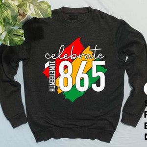 May include: A dark gray sweatshirt with a colorful graphic design that says "celebrate Juneteenth 865".