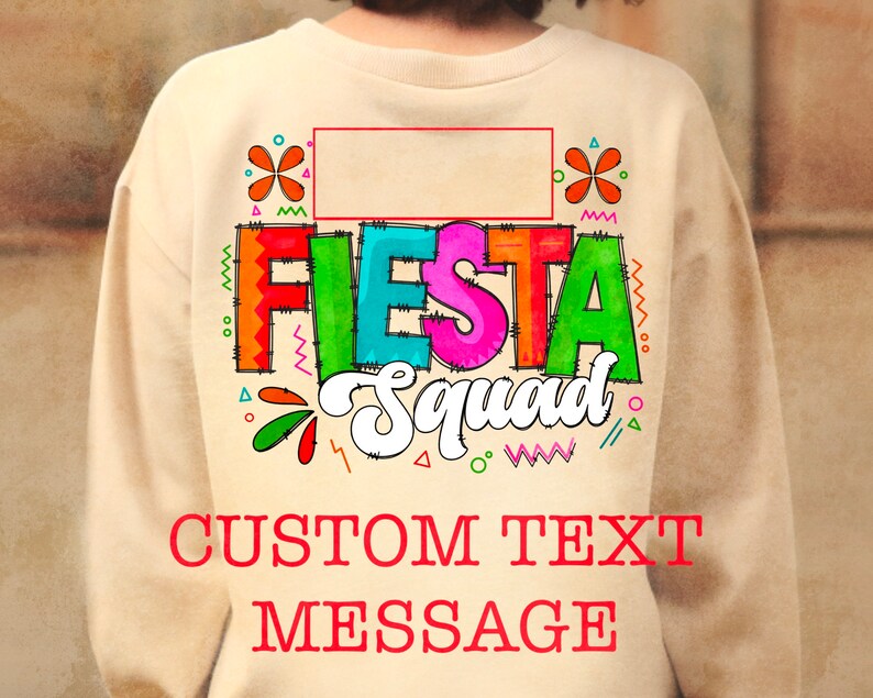 May include: A tan sweatshirt with a colorful "Fiesta Squad" graphic and a blank space for custom text. The graphic features a colorful flower design and a border of zigzags and dots.