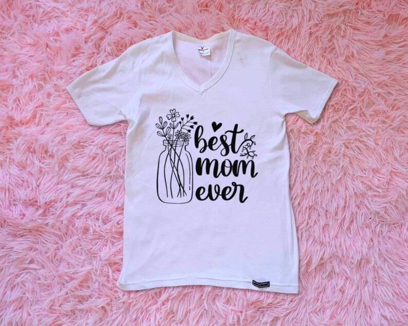 Op de afbeelding: Wit T-shirt met een zwarte afbeelding van een glazen pot gevuld met bloemen en de tekst "best mom ever".