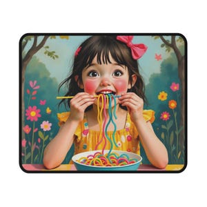 May include: A rectangular mousepad featuring a cartoon illustration of a young girl eating colorful spaghetti. She wears a yellow dress and a pink bow. The background shows a garden with flowers and trees.