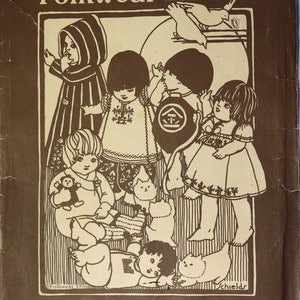 May include: A brown and white paper sewing pattern envelope titled Folkwear 109 Little Folks. The cover features a line-art illustration of five children in various garments, two birds, and two cats. Text includes Folkwear, 109, Ethnic Patterns, Little Folks, Folkwear for infants and toddlers from Morocco, Mexico, Turkey, Japan and Nepal, and Folkwear 1976.