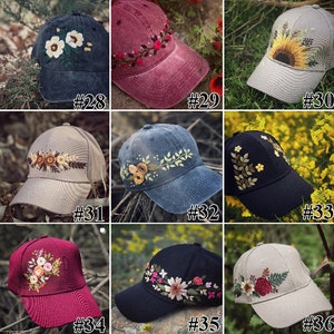 Puede incluir: Nueve gorras de béisbol bordadas con diferentes diseños florales. Las gorras son de diferentes colores, incluyendo negro, azul, gris, rojo y beige.