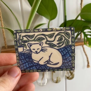 Impresión en linóleo de gato dormido y planta de interior - pegatinas de vinilo