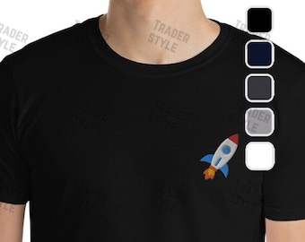 May include: A black t-shirt with a small, colorful rocket ship graphic on the left side of the chest. The rocket ship is red, blue, and yellow.