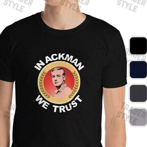 Puede incluir: Camiseta negra con un gráfico circular dorado que presenta la cara de un hombre y el texto "In Ackman We Trust".
